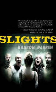 Cover art for Slights: a dark, blurred photo showing a woman from behind facing four people of both sexes leering at her, with eerily distorted faces and open mouths.