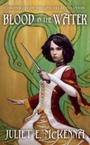 cover art for Blood In The Water by Juliet McKenna, with illustration showing a pale, dark haired young woman in a white, red and gold gown, wielding a sword
