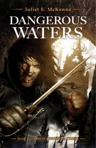 Cover image for Juliet E McKenna's Dangerous Waters, showing a Caucasian looking man with dark hair grimacing and brandishing a sword in his gloved hand. His other hand is in shackles.