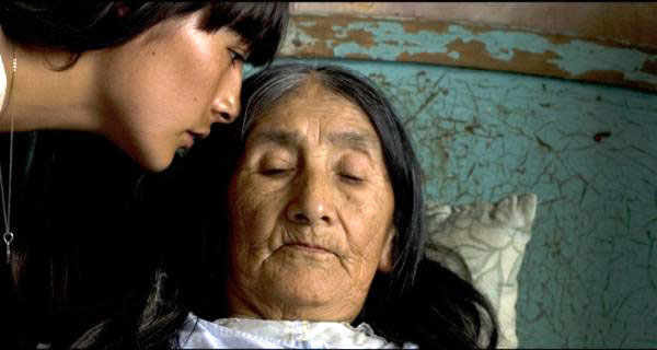 Still from The Milk of Sorrow, Fausta leans down to her mother's face on a bed